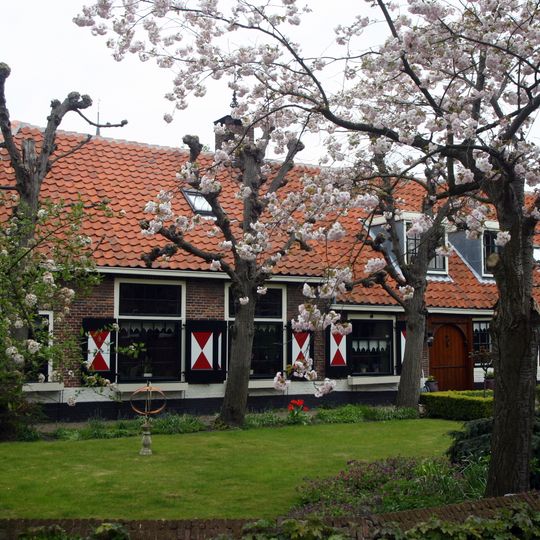 Lage boerderij, dwarshuis met opkamer met kleine roeden en halve luiken. Tot bungalow verbouwd