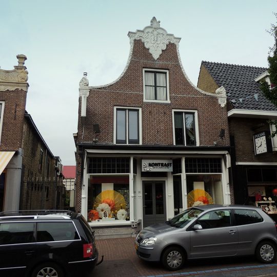 Pand onder zadeldak tegen klokgevel met gebeeldhouwde aanzetkrullen, lijst en bekroning