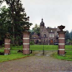 Vier bakstenen hekpijlers met banden van natuursteen