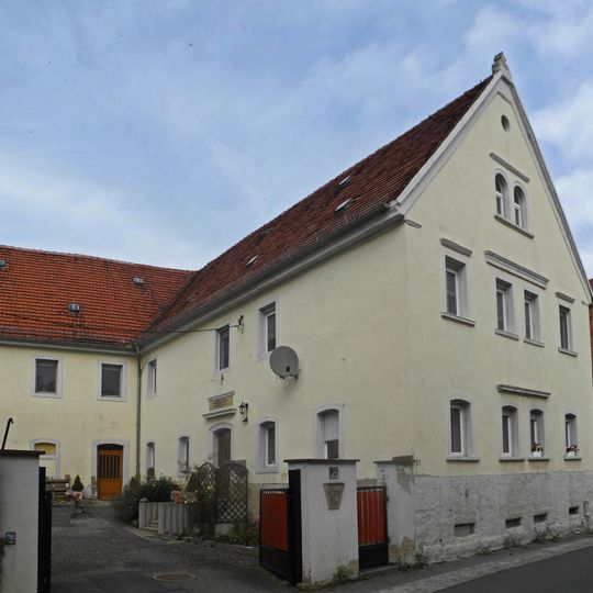Wohnhaus, daran angebautes Seitengebäude und weiteres Seitengebäude eines ehemaligen Vierseithofes sowie Schlussstein in der Hofmauer Pirnaer Straße 31