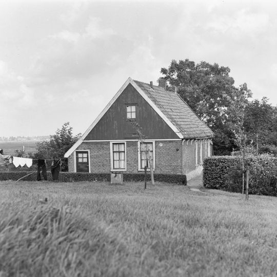 Huisje, nabij de Hervormde Kerk van Haringhuizen, onder zadeldak met houten geveltoppen en met zesruitsschuifvensters