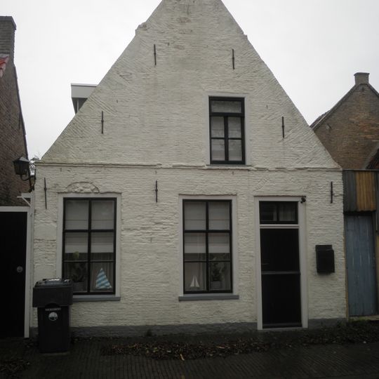 Pandje met voorgevel met beitelingen en uit het midden geplaatst zolderraam onder zadeldak tussen puntgevels