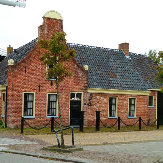 Pand met een deel onder zadeldak tegen halsgevel en een haaks daarop staande vleugel onder aansluitend zadeldak