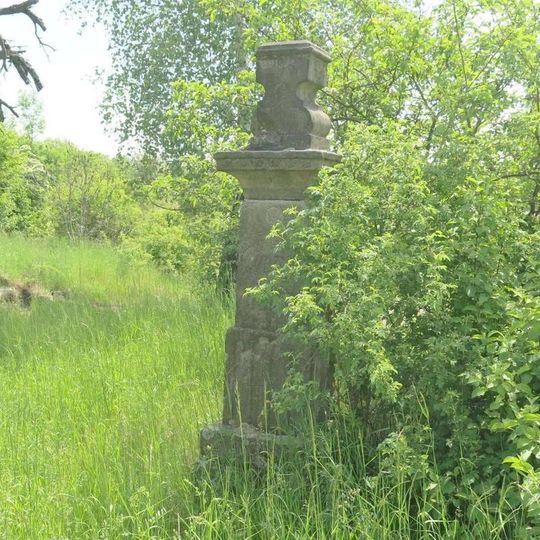 Podstavec s ulomeným křížem nad tratí u zastávky Třebenice město