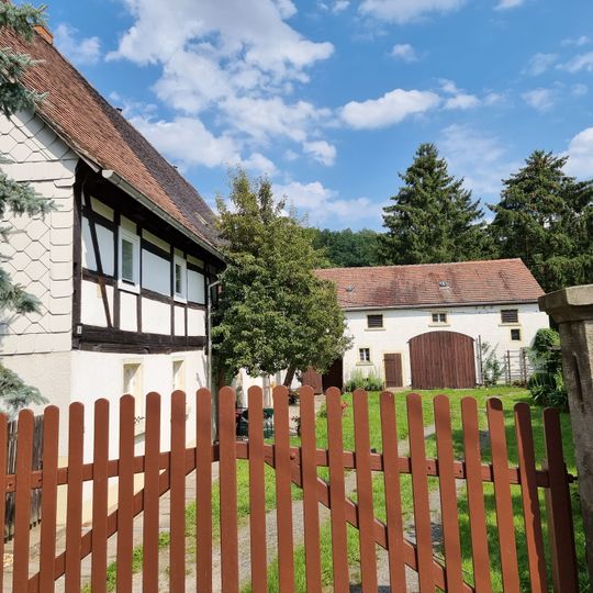 Wohnstallhaus, Scheune und zwei Sandsteinpfeiler eines Bauernhofes Lindenstraße 6