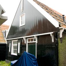 Perceelsgedeelte van een grotendeels houten huis