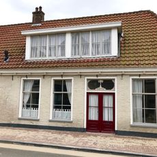 Pand onder zadeldak tegen vernieuwde topgevel aan pleinzijde