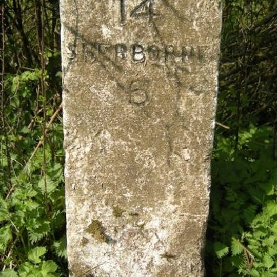 Milestone, entrance to Dunn's Farm 150m S of church.