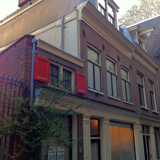 Huisje onder rechte lijsten plat dak met steile schilden