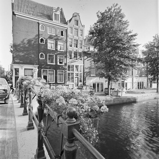 Pand waarvan de latere gevel op hoge houten pui wordt beëindigd door een klokvormige top onder rollagen