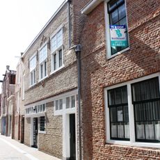 Pakhuis met nok evenwijdig aan de straat. Puibalk