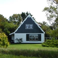 Grote boet met op de houten voorgevel geschilderde deurboog (gebruikelijk motief van Texelse boerderijen)