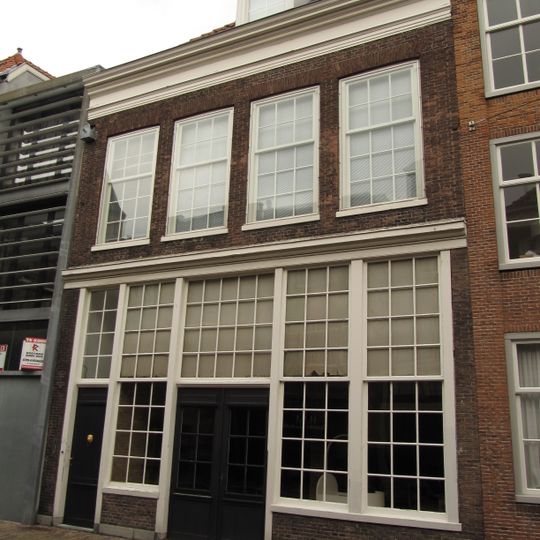 Pand met eenvoudige lijstgevel met hoge houten pui en in de verdieping empire ramen