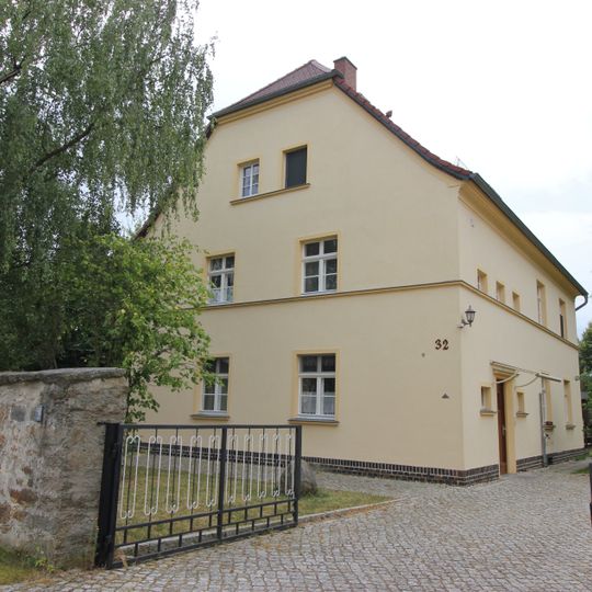 Pfarrhaus und Gemeindehaus eines Pfarrhofes, mit Pfarrgarten und Einfriedungsmauer Dorfplatz 32