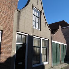 Huis met gepleisterde klokgevel