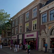 Pand met bakstenen empiregevel en forse kroonlijst met zoldervensters en jongere onderpui