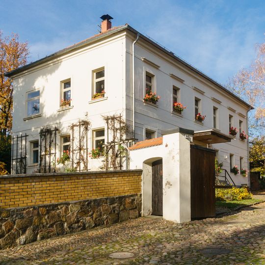 Pfarrhaus, zwei Seitengebäude, Toranlage, Einfriedungsmauer und Hofpflasterung eines Pfarrhofes Lange Straße 17