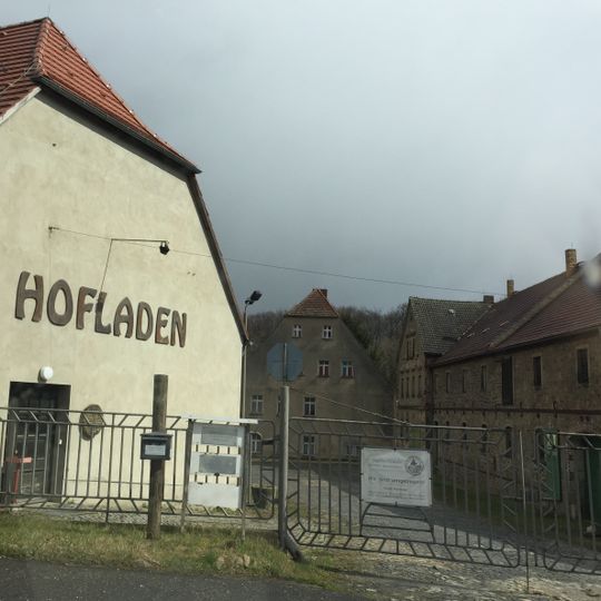 Herrenhaus, Gutscheune und drei Wirtschaftsgebäude, davon das südliche Gebäude mit Wohnhausanbau, Hofpflaster, das Denkmal der Liebe, eine Brücke und eine Steinbank im Gutspark sowie zwei Teiche An der Landeskr
