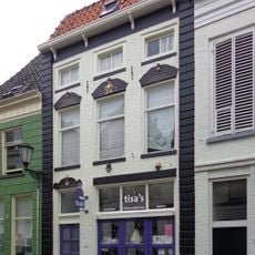 Pand met gevel met jongere gootlijst en werkplaatsingang