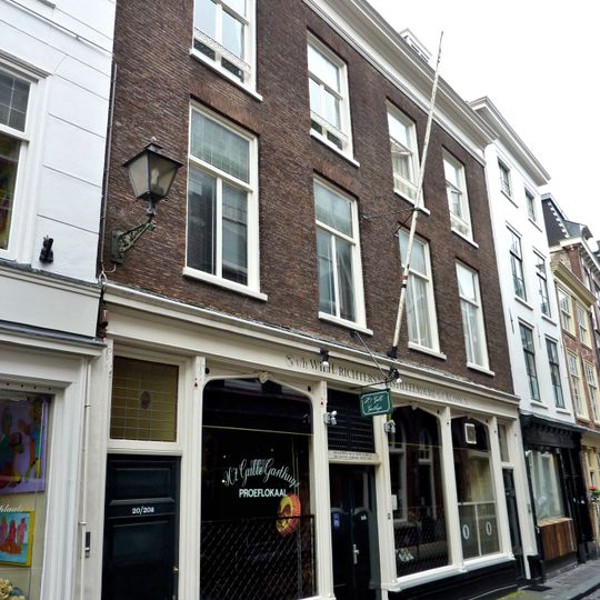 In oorsprong twee panden, samengetrokken achter een lijstgevel ter breedte van vier vensterassen