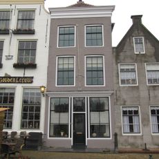 Pand met eenvoudige bakstenen gevel onder rechte lijst