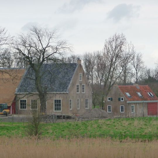 Bakstenen woonhuis met pannen zadeldak. Bakgoot op klossen. Dicht bijeen liggende staafankers aan lange zijden. Eenruits ramen met rollagen. Deur met eenruits bovenlicht.