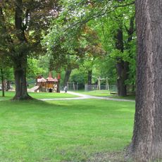 Parkanlage Lutherpark mit Wegeführung, historischem Baumbestand, Steinbank mit Inschrift, Luthereiche, Lutherstein und Gedenkstein für den Stadtbrand 1813 Am Lutherpark