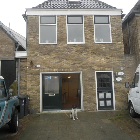 Eenvoudig pandje met topgevel van gele steen met beitelingen