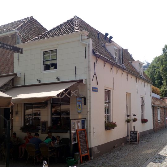 Huis met gepleisterde lijstgevel en met afgeschuinde hoeken