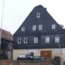 Ehemaliges Wohnhaus eines Bauernhofes, mit Torbogen und Einfriedung des Vorgartens August-Bebel-Straße 6