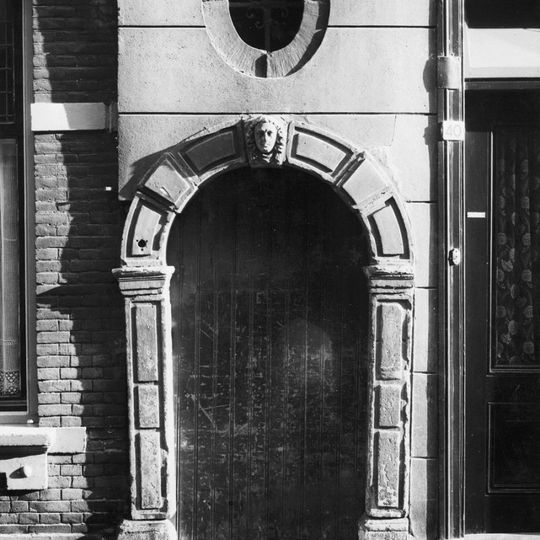 Poortje met geblokte versiering van de omlijsting en sluitsteen met maskerconsole