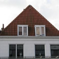 Pand met forse lijstgevel onder fraaie kap met topschoorsteen. Dakkapel