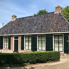 Pand met goot op klossen onder schilddak met hoekschoorstenen (vormt een geheel met nr. 10)