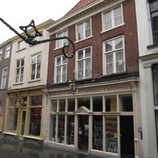 Huis met hoog schilddak, kroonlijst op klossen en lage zolderverdieping