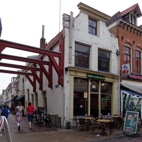 Pand met gepleisterde lijstgevel met ingezwenkte hoeken en winkelpuitje