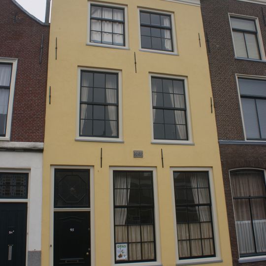 Pand met gepleisterde lijstgevel met recente kroonlijst. Ondergevel gewijzigd