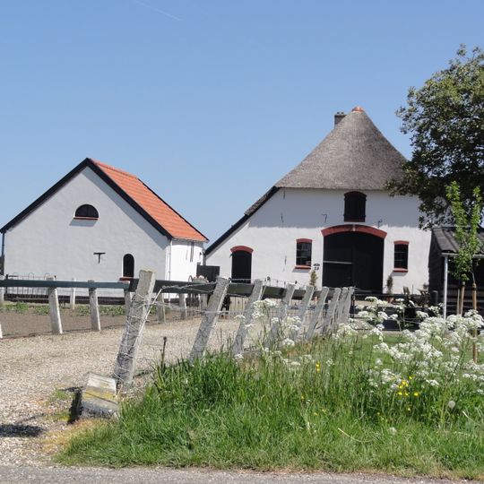 Gepleisterde boerderij met wolfdak, gedekt door riet en pannen
