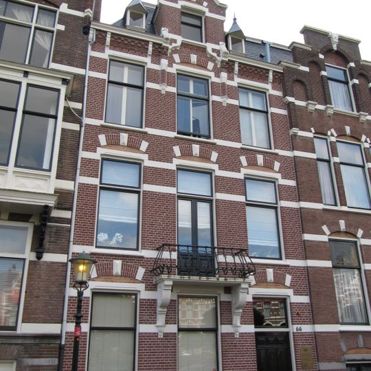 Pand in neo-renaissance trant met trapgevel boven de middenas. De gevel is versierd met geblokte ontlastingsbogen en banden