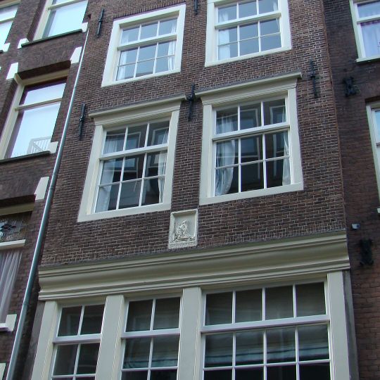 Huis met op de originele bolle puibalk overgebouwde gevel onder klokvormige top met rollagen