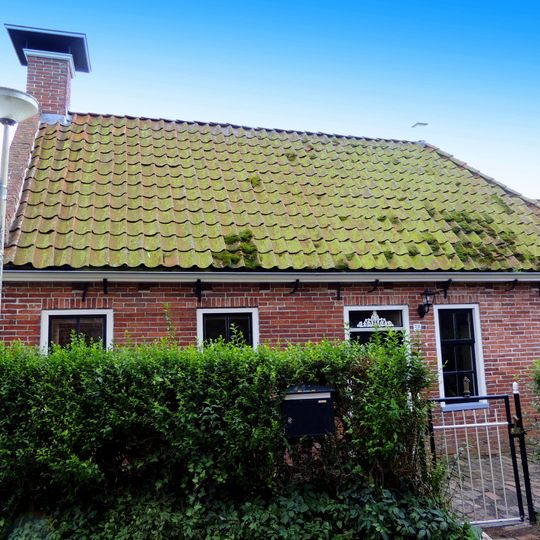 Landelijk pand met zadeldak tegen gesloten topgevels