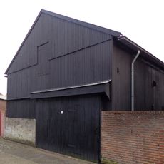 Schuur op stenen onderbouw. Oorspronkelijke spanten en kap in rondhout en bekapt hout