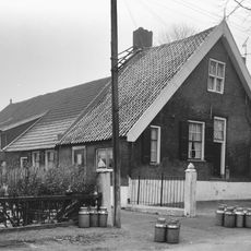 Nabij de oude toren gelegen boerderij, waarvan het woongedeelte een puntgevel heeft met in de top een kruiskozijn. Overigens vensters met kleine roedenverdeling en luiken; vloeddeur met bovenlicht.
