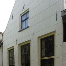 Huis met gepleisterd puntgeveltje, parterre met zolderverdieping