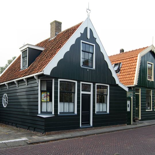 Houten huis voorzien van voorschot met geschulpte lijst en topmakelaar met Lod.XVI-ornament