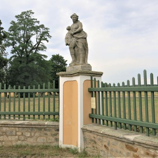 Alegorická socha Červenec v ohradě zámecké zahrady ve Veltrusech