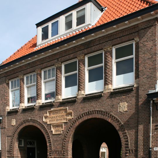 Rij woningen met poortgebouw maken deel uit van het U-vormige woningcomplex