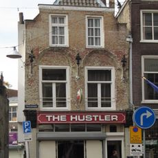 Hoekpand Grote Appelsteiger. Afgeknotte, gepleisterde trapgevel van het Dordtse type met mooi gehouwen kraagstenen en sierankers