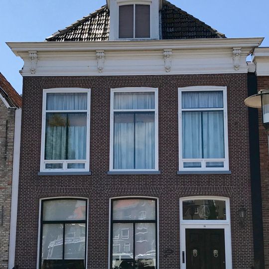 Pand met lijstgevel waarboven dakkapel en voorschild met schoorsteen met bord