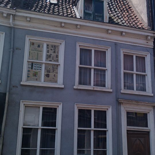 Woonhuis onder zeer hoog zadeldak, waarin dakkapel met fronton en vleugelstukken