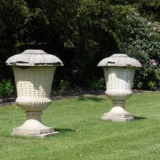 Twickel: natuurstenen urnvormige tuinvazen rozentuin net deksel op voetplaat, rijk gedecoreerd in relief